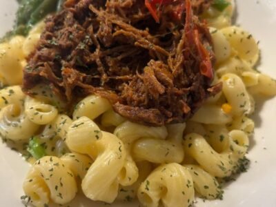 MAC and Cheese Tropical Macaronis à la sauce crémeuse cheddar, Garnis d’oignons verts et de chapelure croustillante. Optionnel: extra saucisse ou poulet 3$