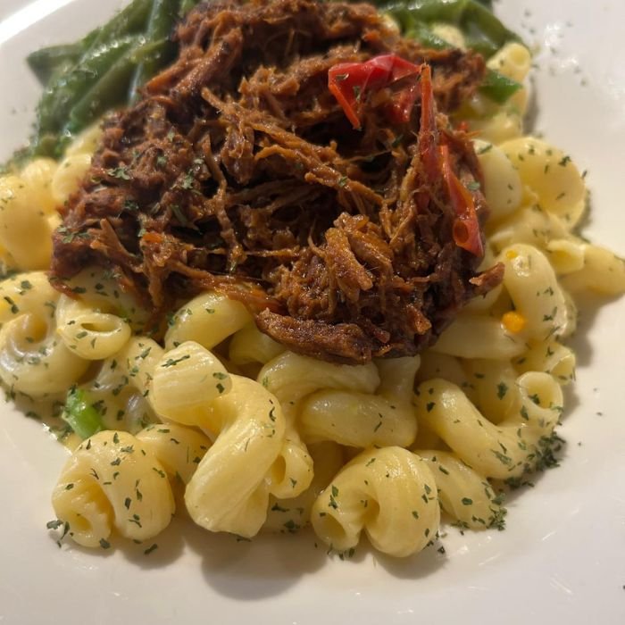 MAC and Cheese Tropical Macaronis à la sauce crémeuse cheddar, Garnis d’oignons verts et de chapelure croustillante. Optionnel: extra saucisse ou poulet 3$